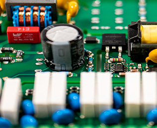 Detaillierte Ansicht einer sorgfältig bestückten Platine mit SMD- und THT-Komponenten, die die Präzision und Qualität unserer Elektronikfertigung demonstriert.